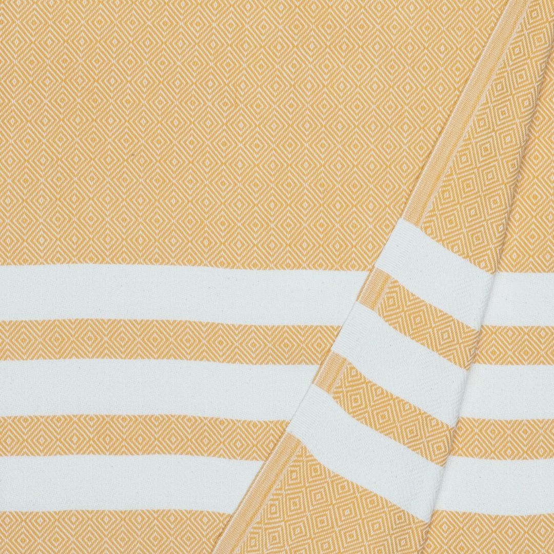 Close-up of yellow fabric with white stripes and geometric patterns