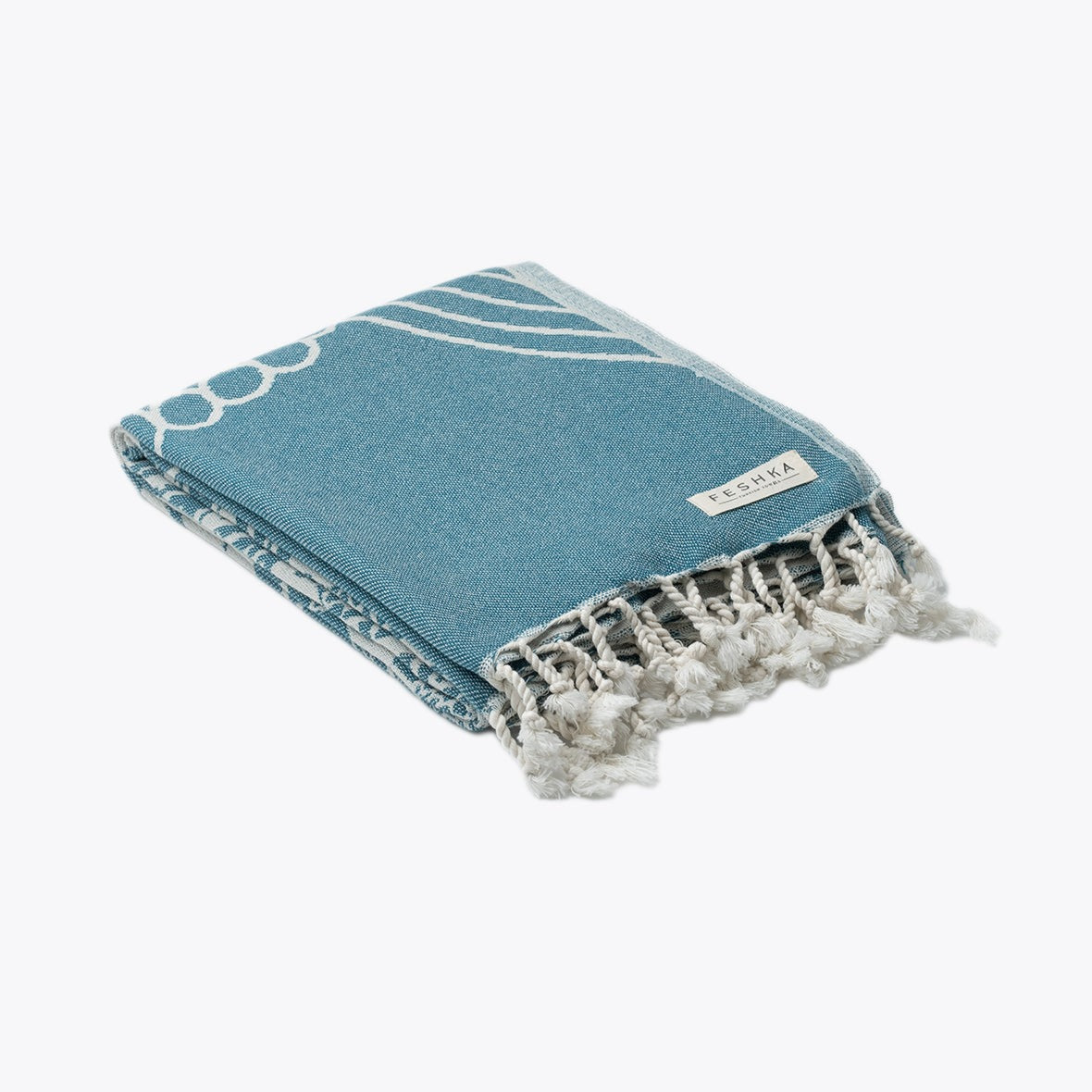 Blue towel with white patterns and fringes on a white background