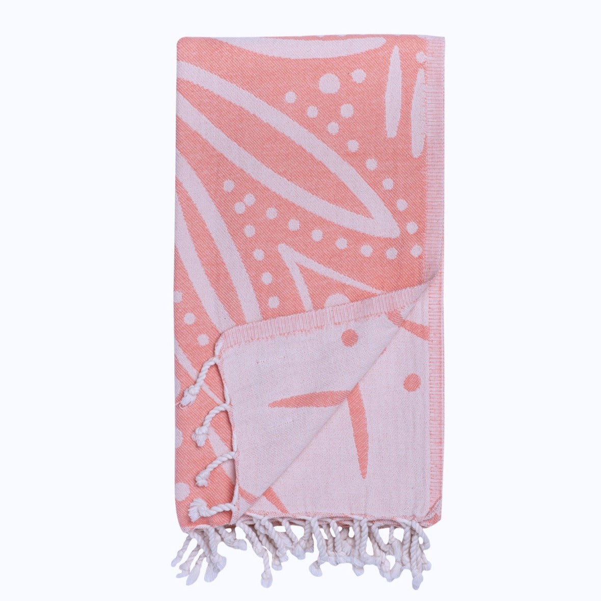 Pink towel with white leaf patterns and tassels on a white background