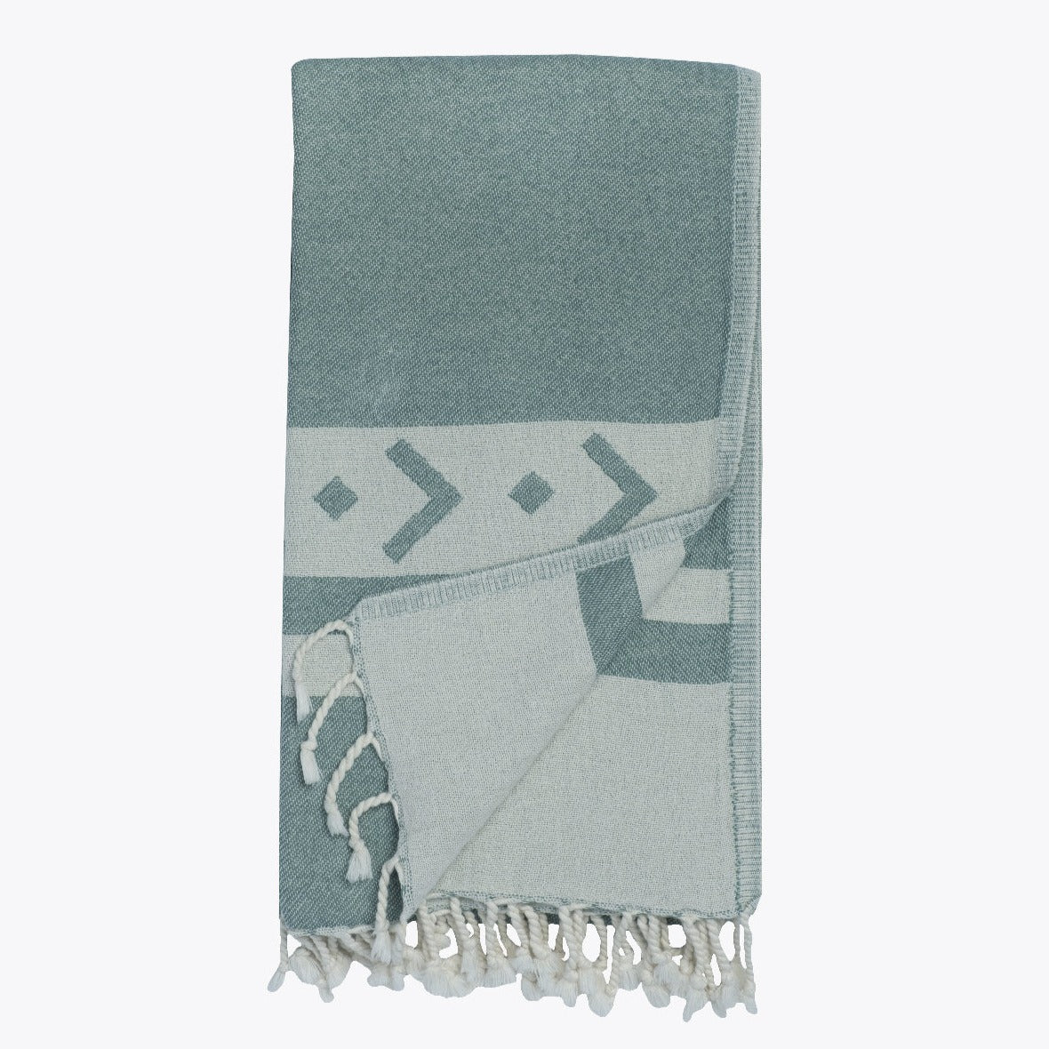 Teal towel with geometric patterns and tassels on a white background