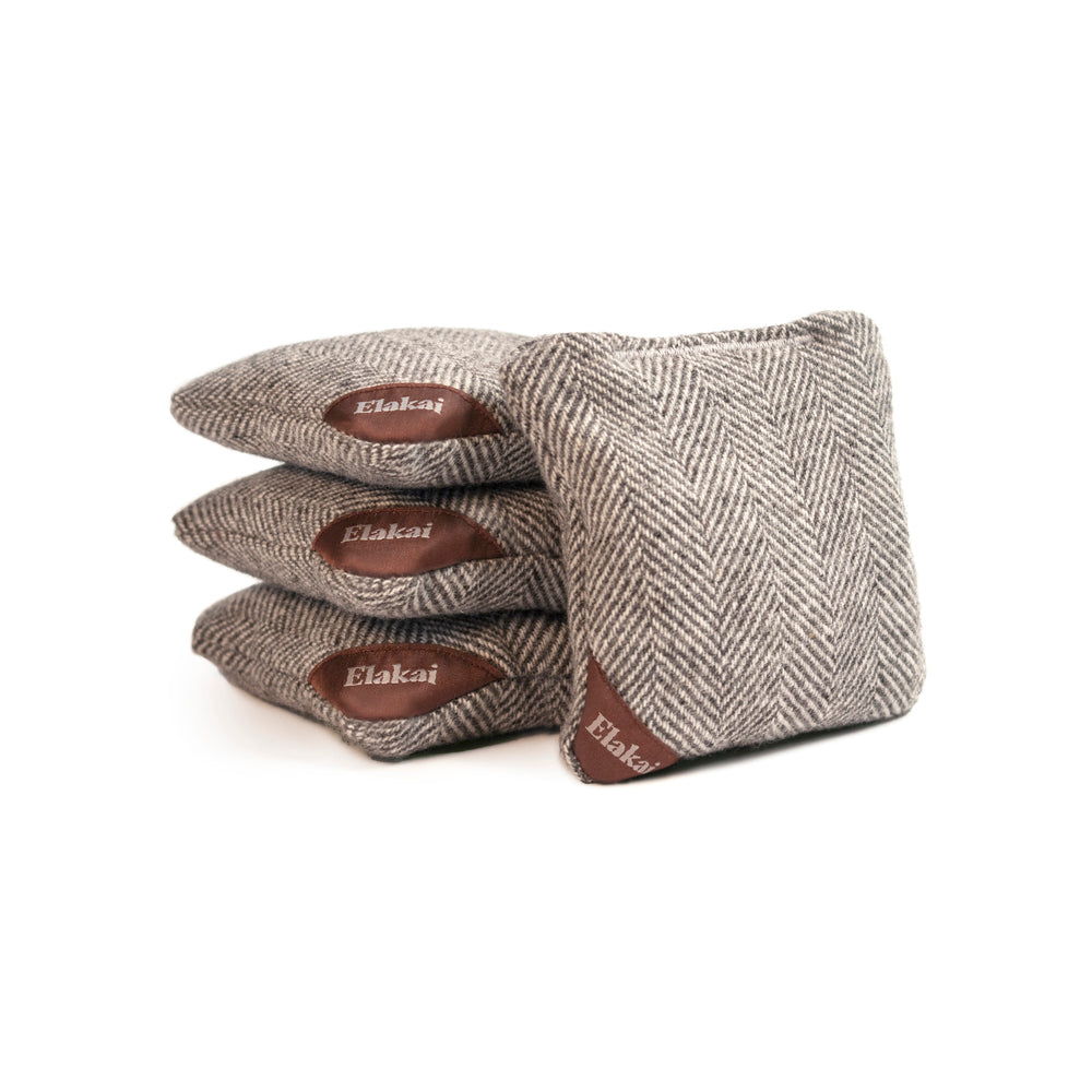 Three pairs of herringbone-patterned gloves with brown labels on a white background