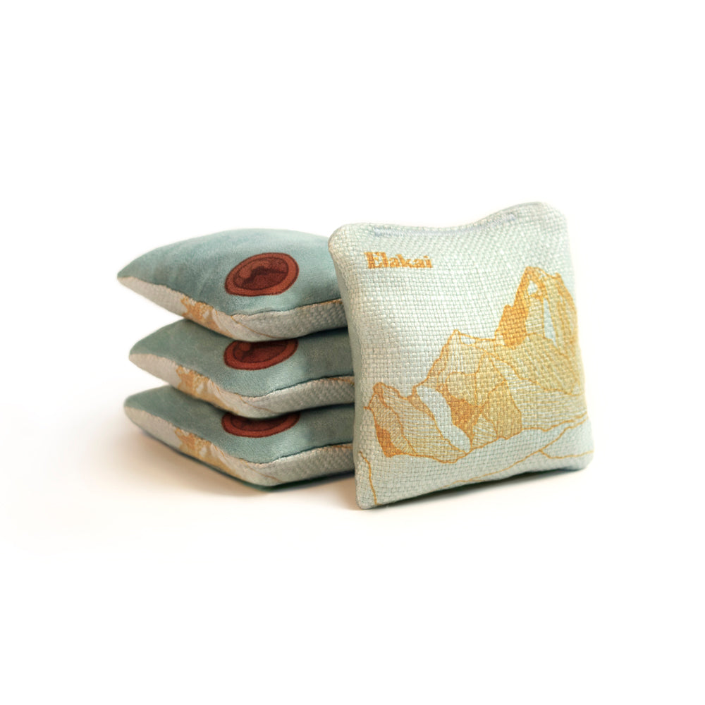 Three fabric bags with mountain designs on a white background