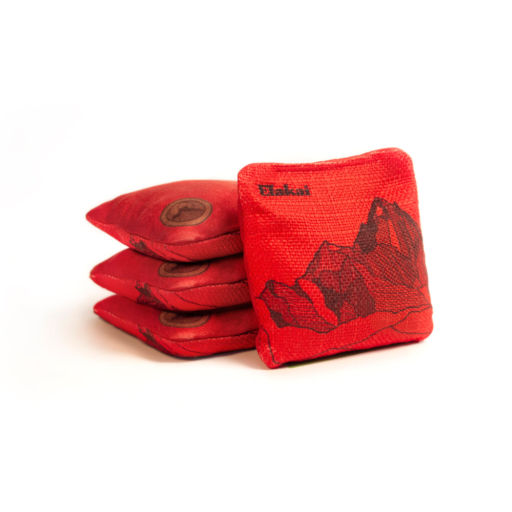 Red cornhole bags with a mountain design on a white background