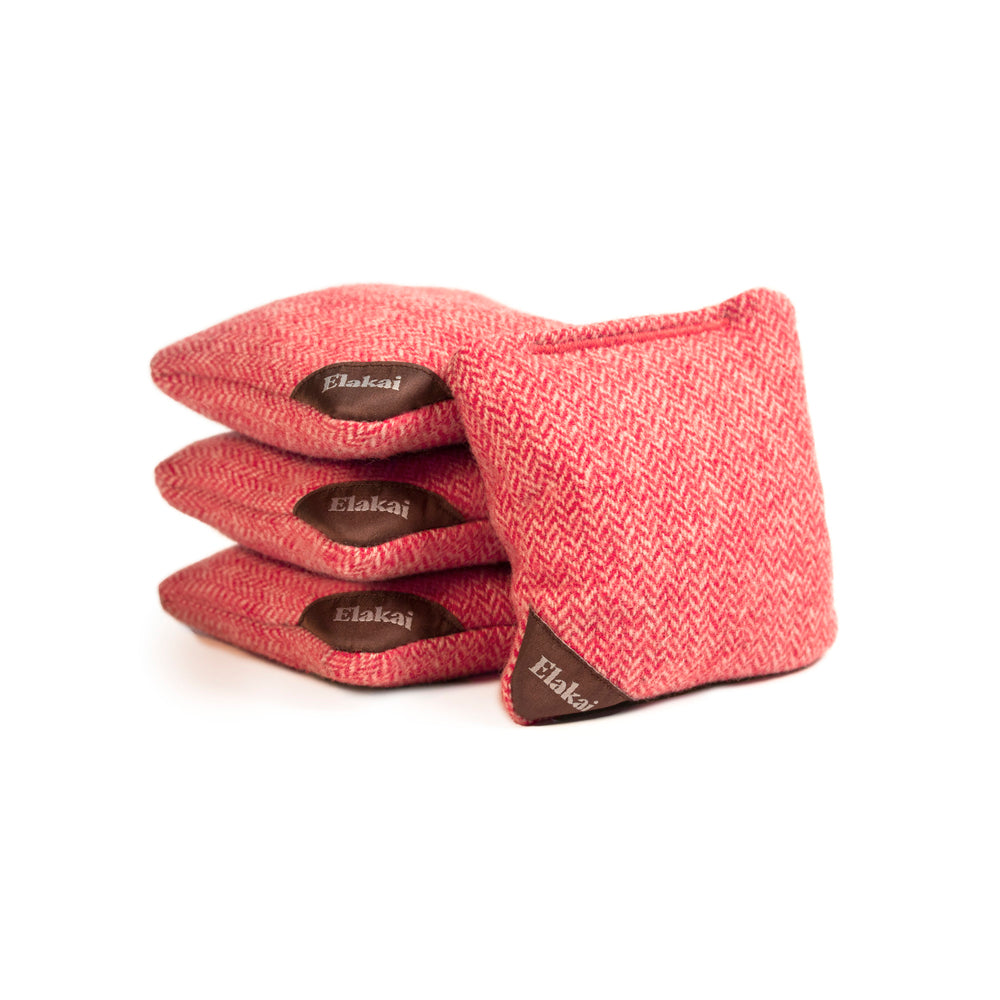 Stack of pink herringbone patterned socks with 'Elakai' branding on a white background