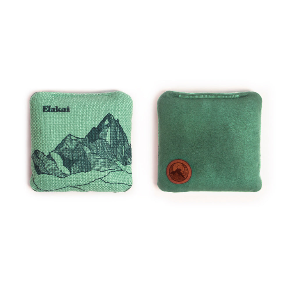 Two green pouches with mountain design and leather patch on a white background