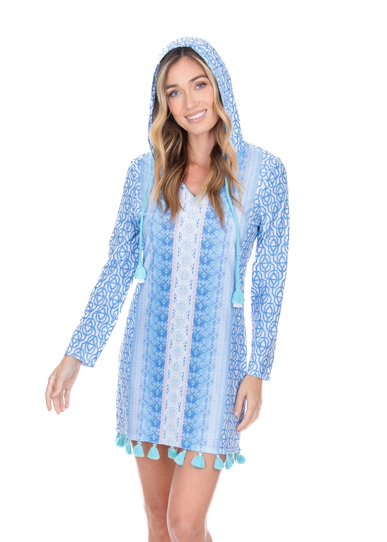 Woman wearing a blue patterned cover-up with pom-pom trim on a white background