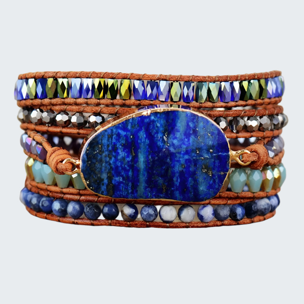 A multicolored beaded bracelet with a large lapis lazuli stone in the center, featuring a variety of colors and patterns, displayed on a wooden surface.