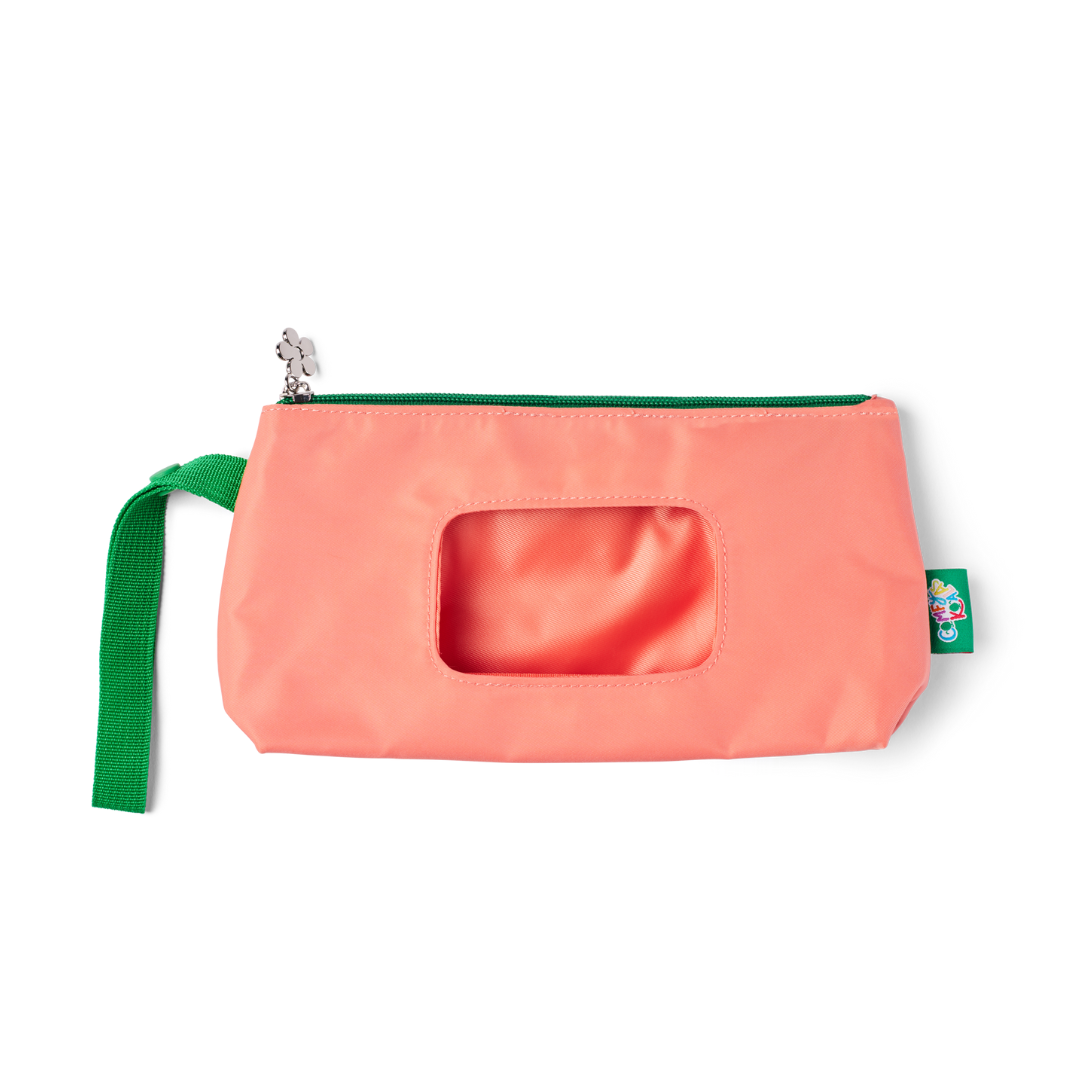 Man sitting on a bench wearing a pink shirt and beige pants in an urban setting.