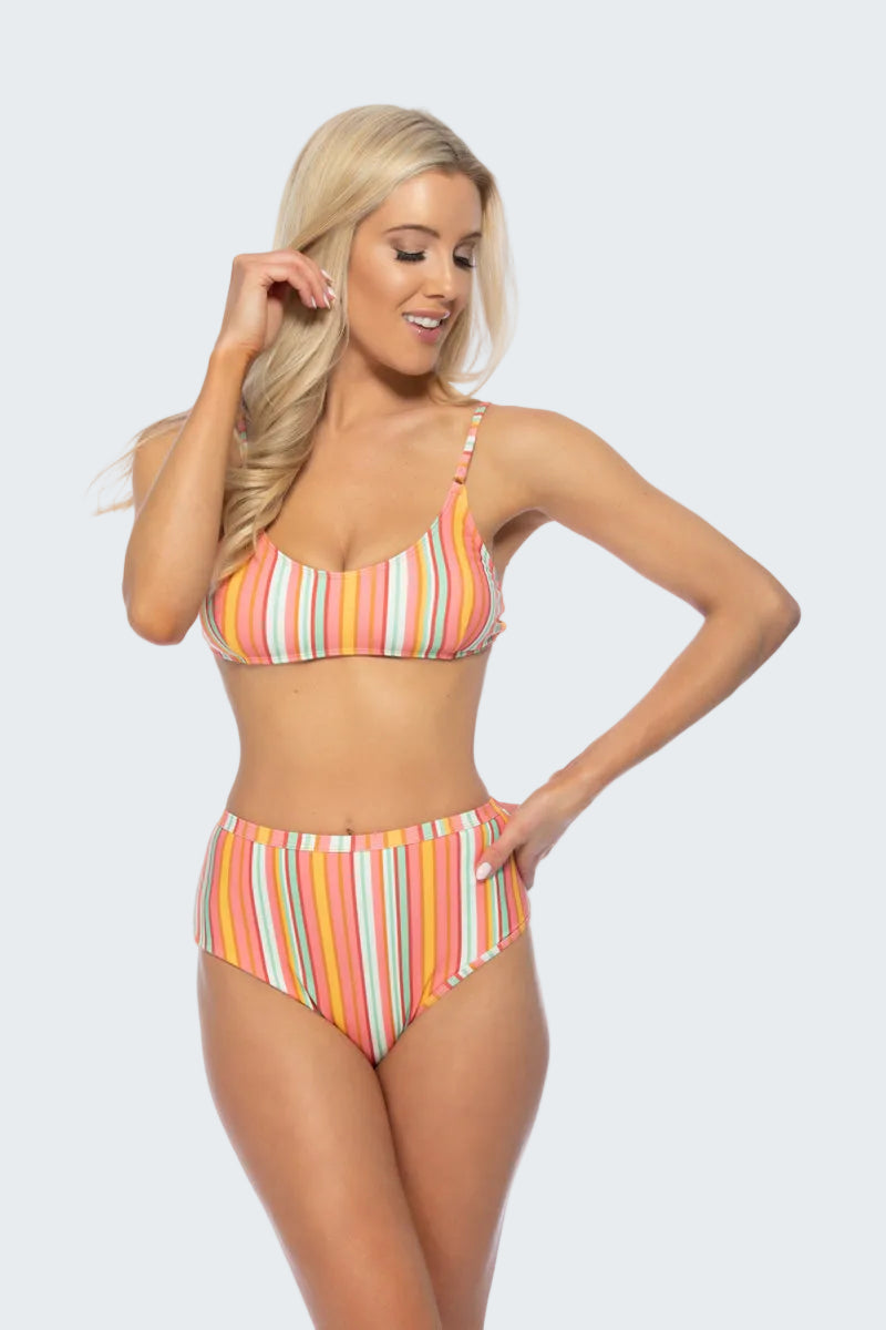 Woman wearing a colorful striped bikini on a white background