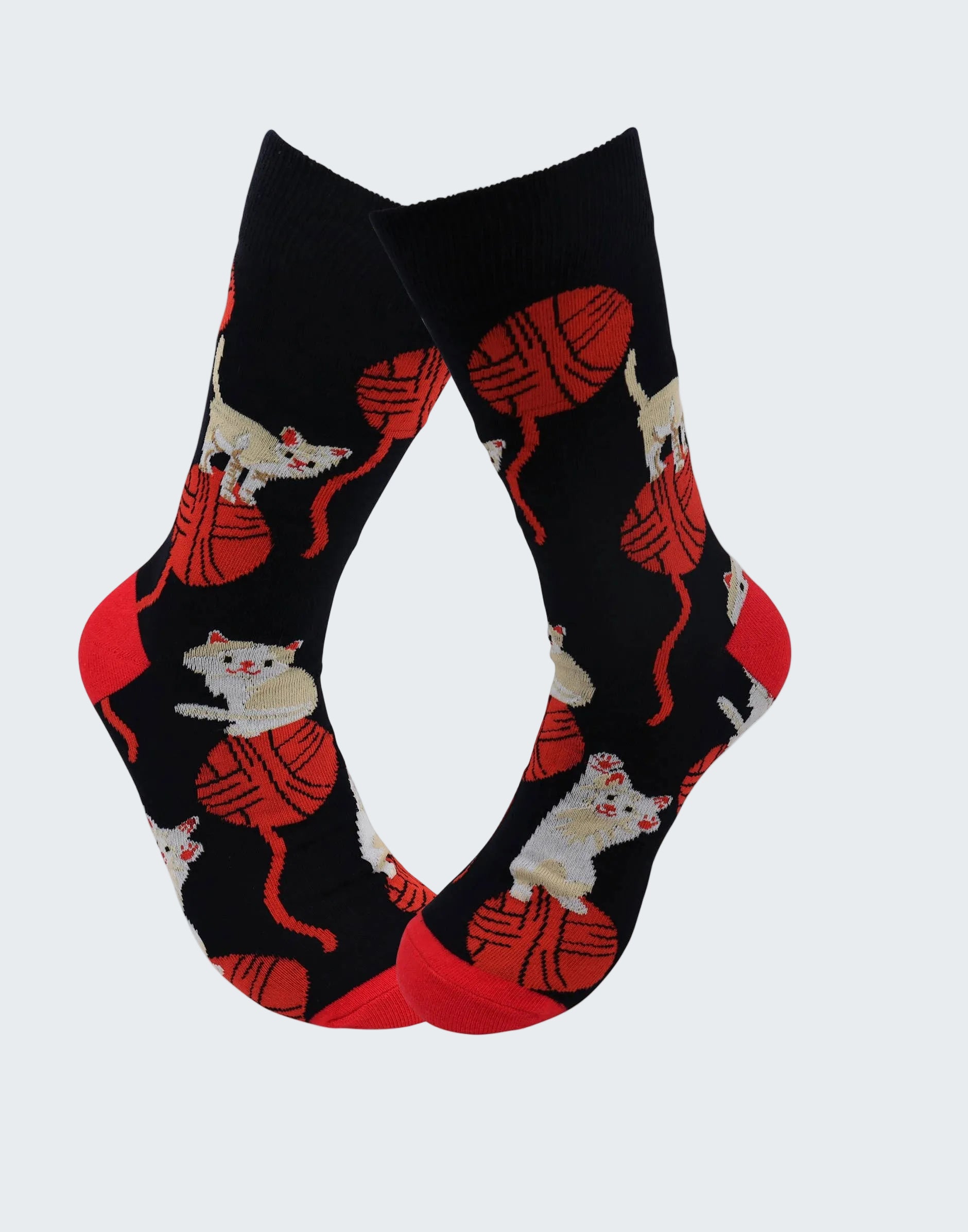 Black socks with red yarn and white cat pattern on a white background