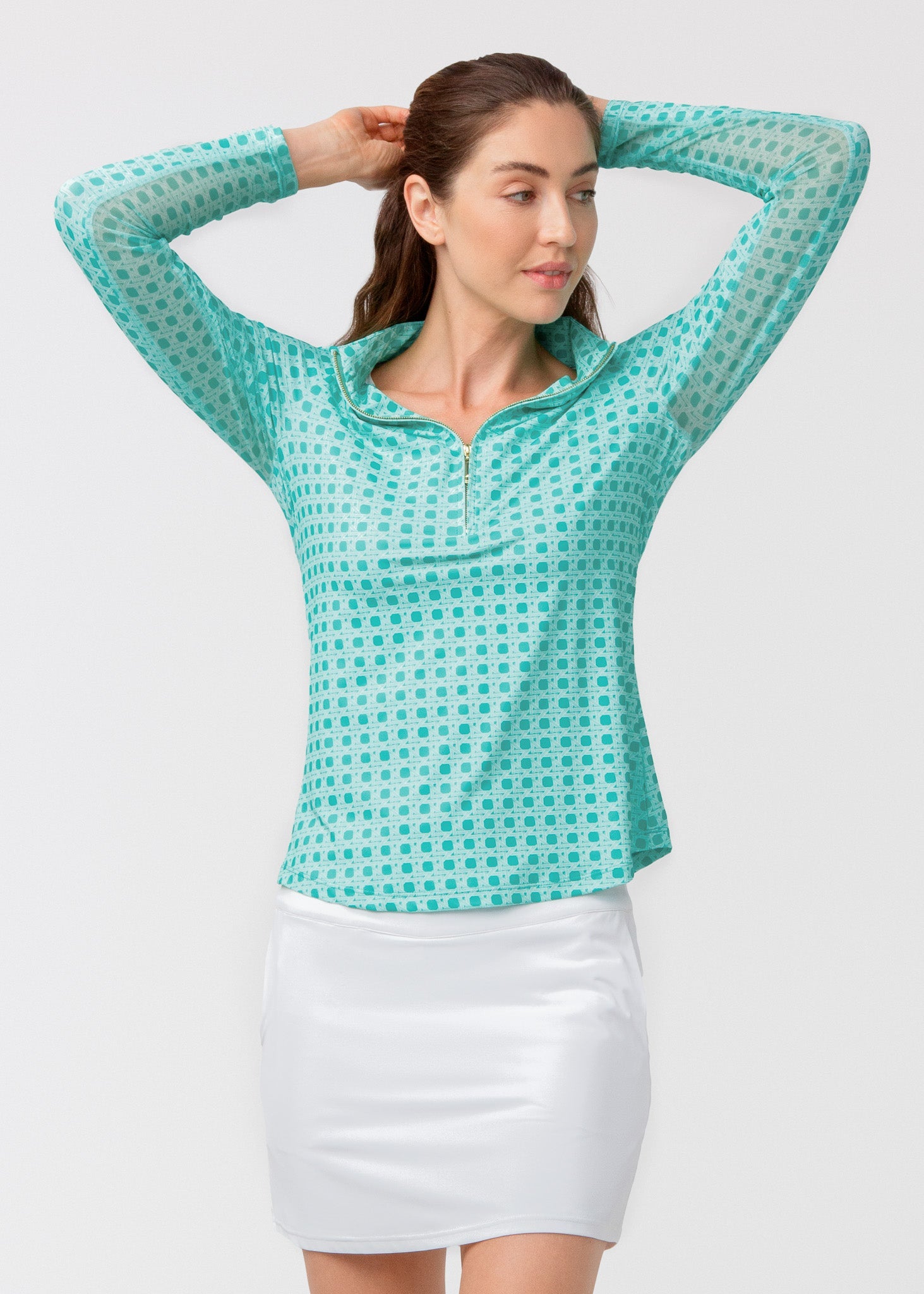 Woman wearing a teal checkered shirt and white skirt on a light gray background