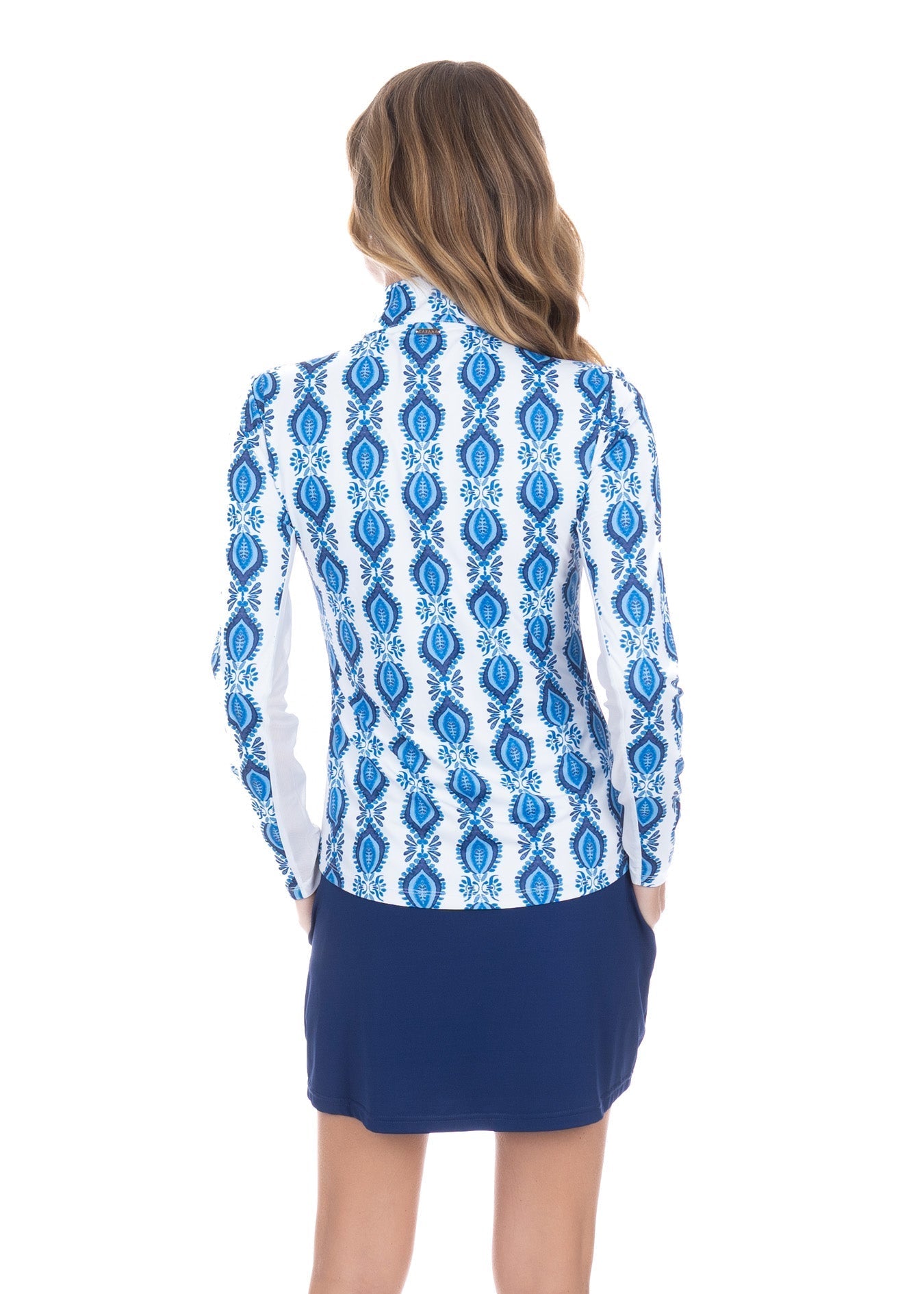 Woman wearing a blue and white patterned blouse with a navy skirt on a white background