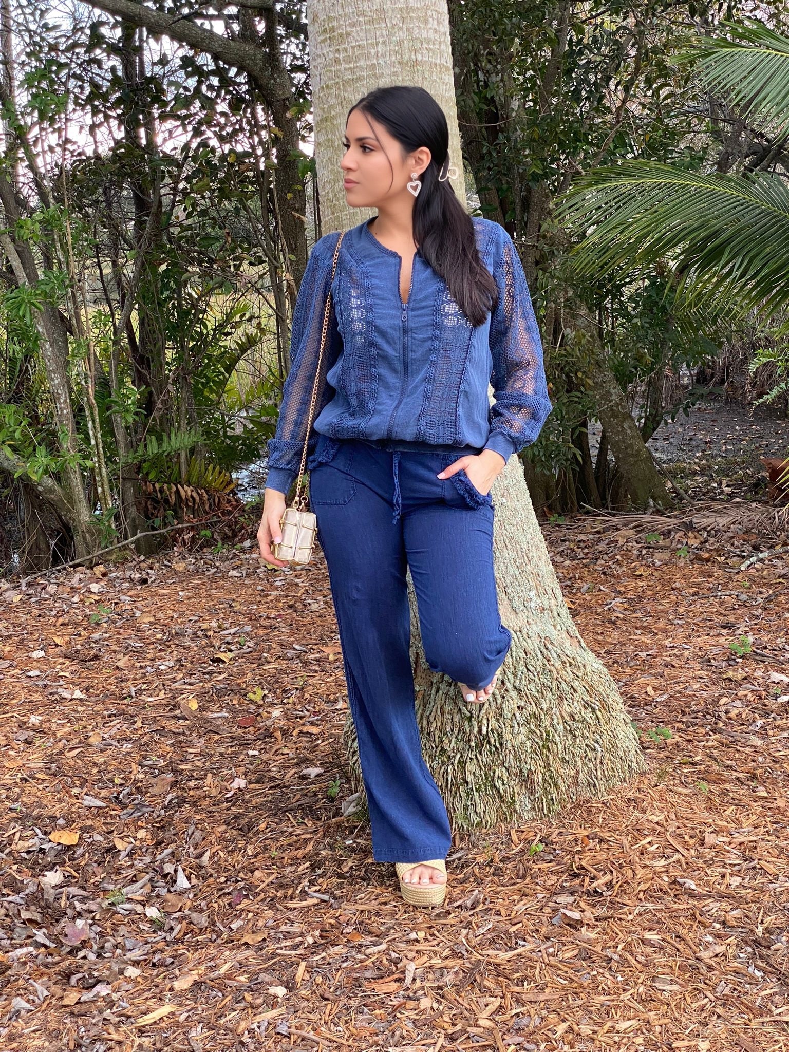 Woman in a blue outfit standing in a forest setting