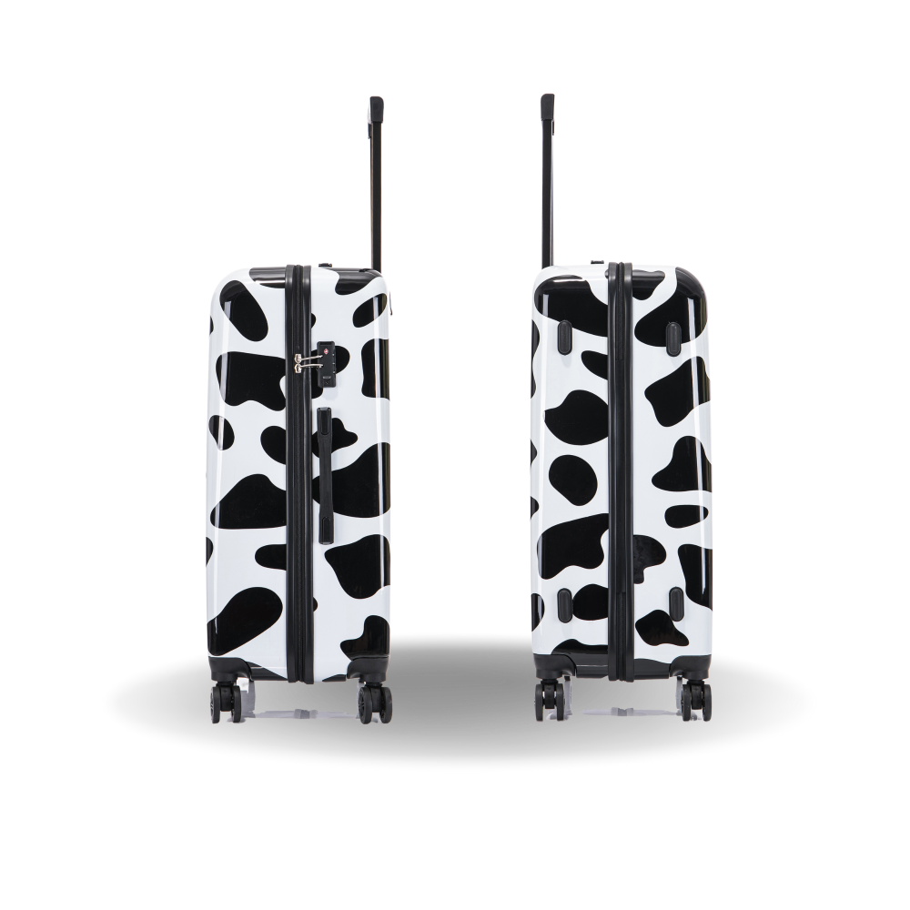 Two black and white cow print suitcases on a white background