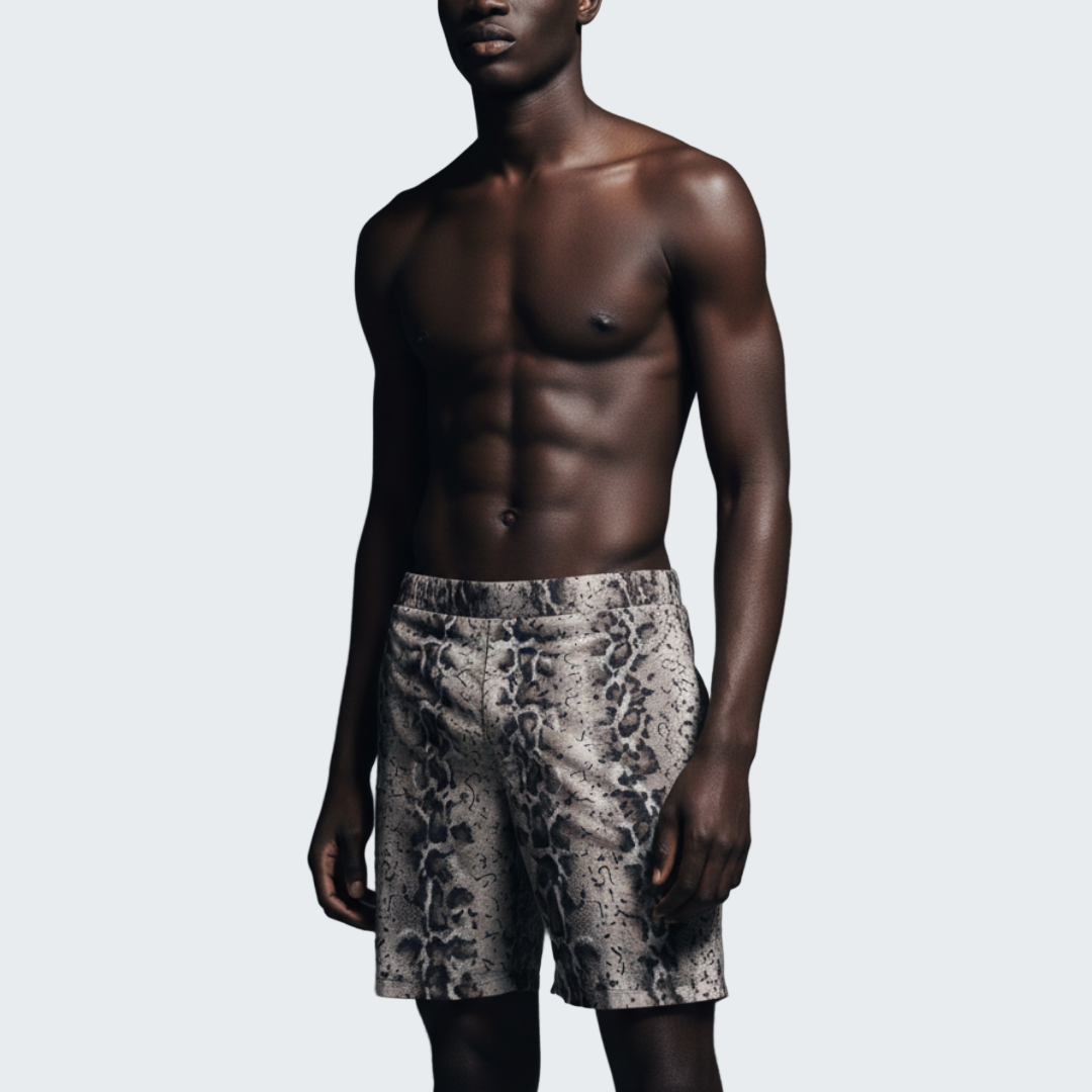 Man wearing patterned shorts against a dark background