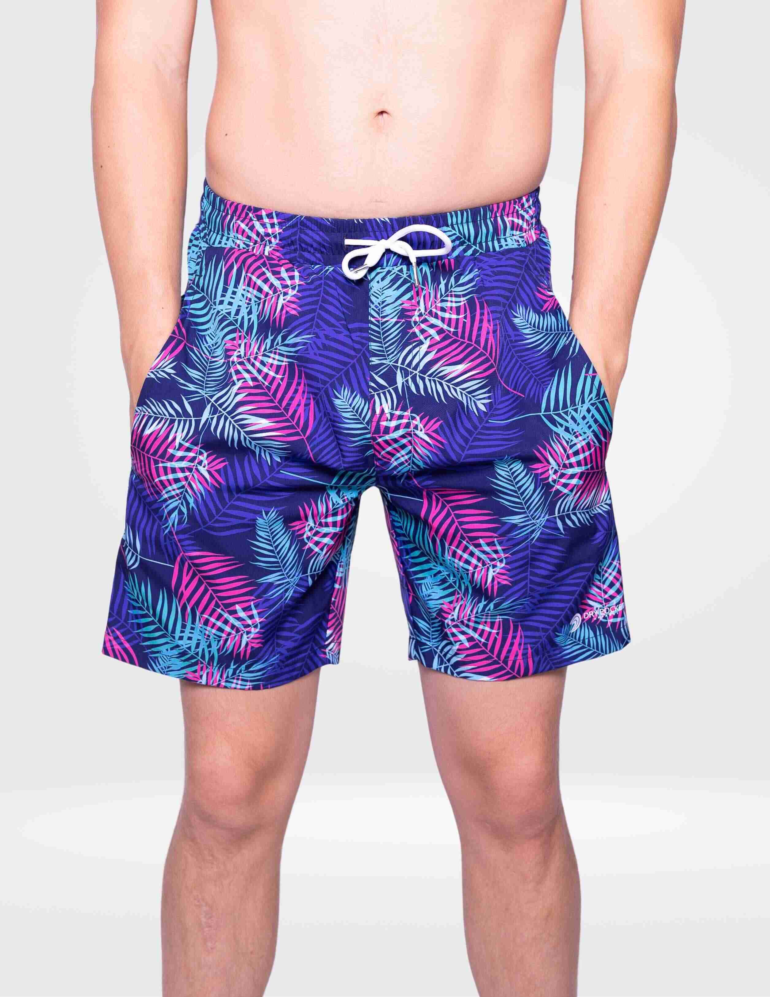 Person wearing purple tropical leaf patterned shorts on a white background