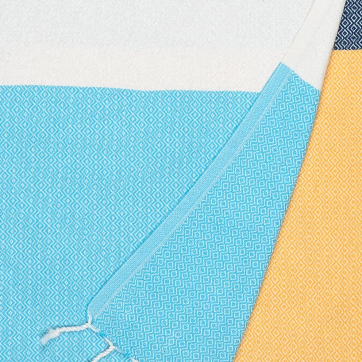 Close-up of blue and yellow textured towels on a white background
