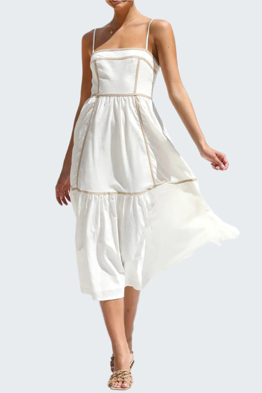 A woman wearing a white square neck midi cami dress with contrast trim, sleeveless, in a standing pose.