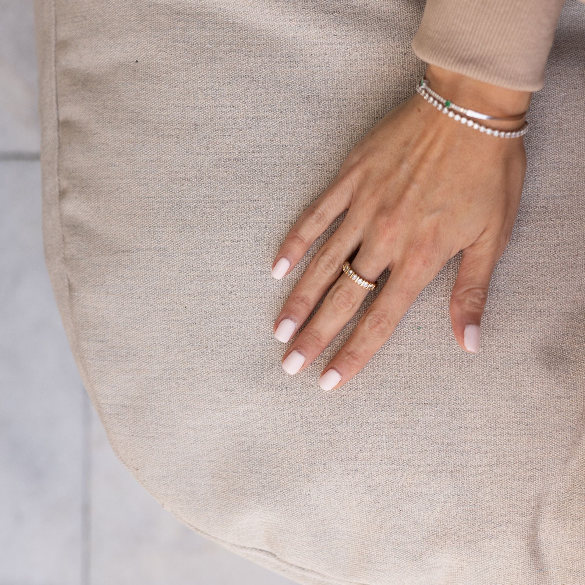 Hand with rings and bracelets on a neutral background
