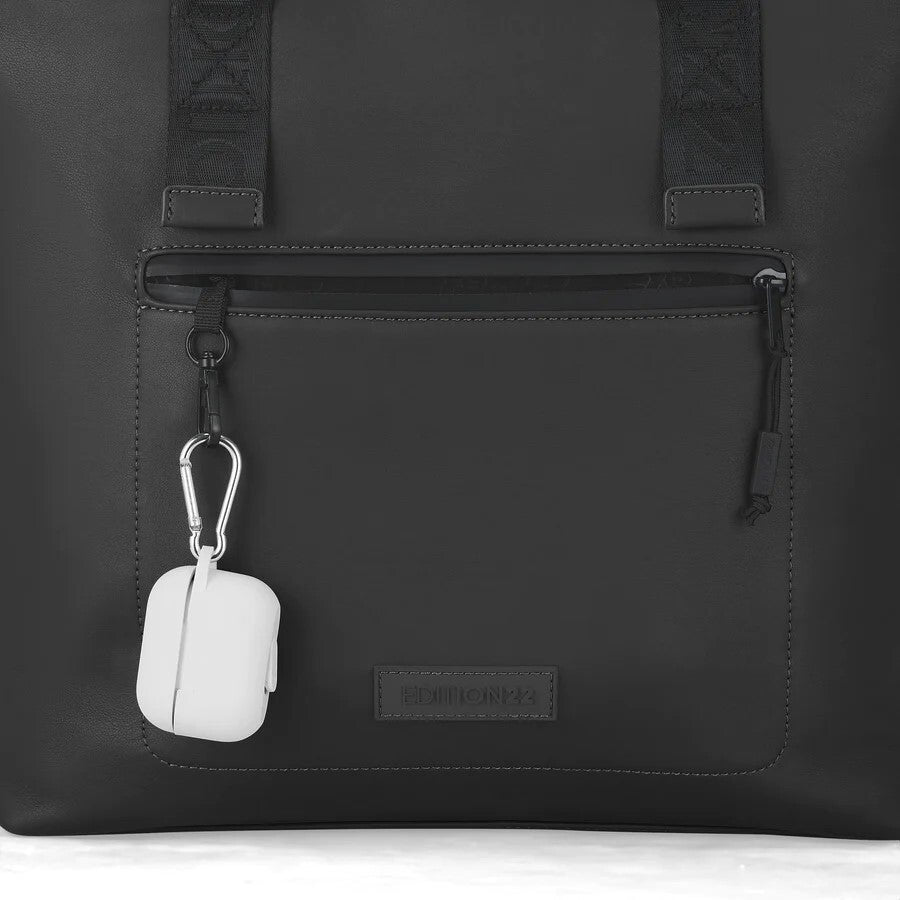 Black backpack with a white air pod case attached to a zipper pull.