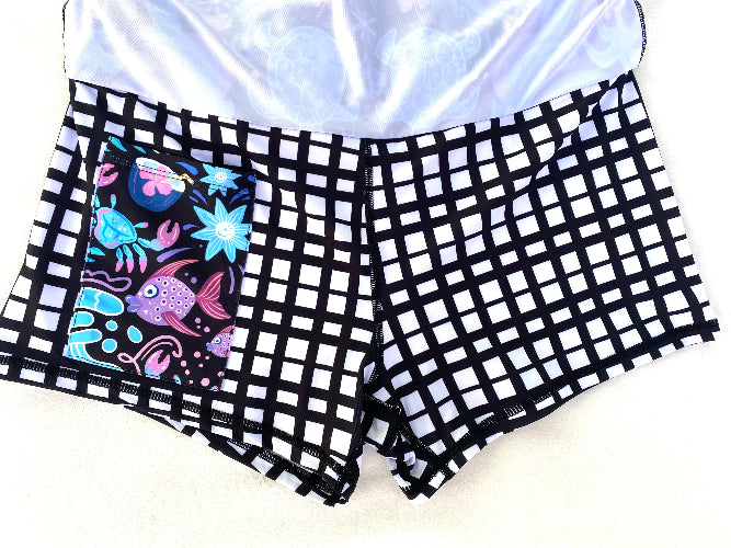 Black and white checkered shorts with a colorful fish design on a white background