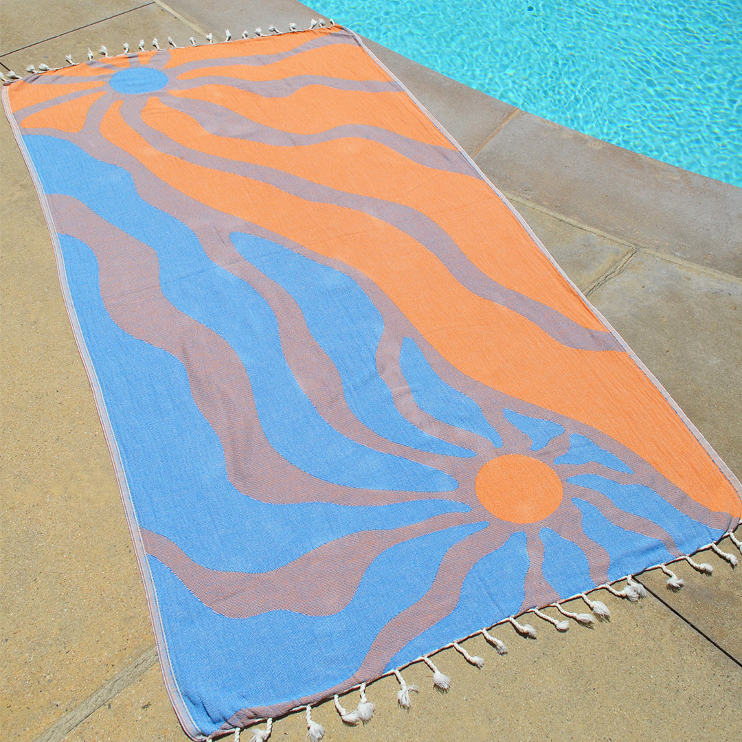 Colorful towel with wavy pattern on a poolside floor