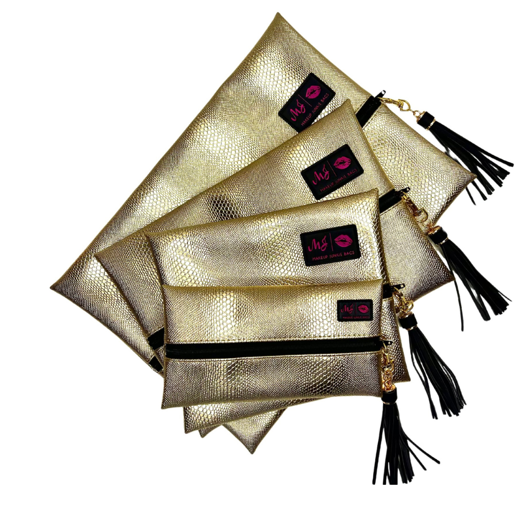 Gold clutch bags with black tassels and visible brand logo on a white background