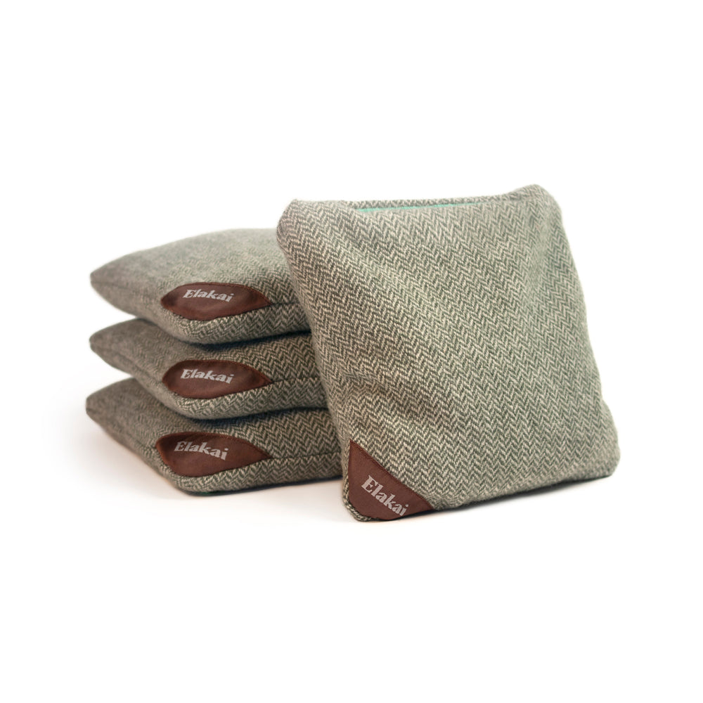 Three green fabric bags with brown Elakai labels on a white background