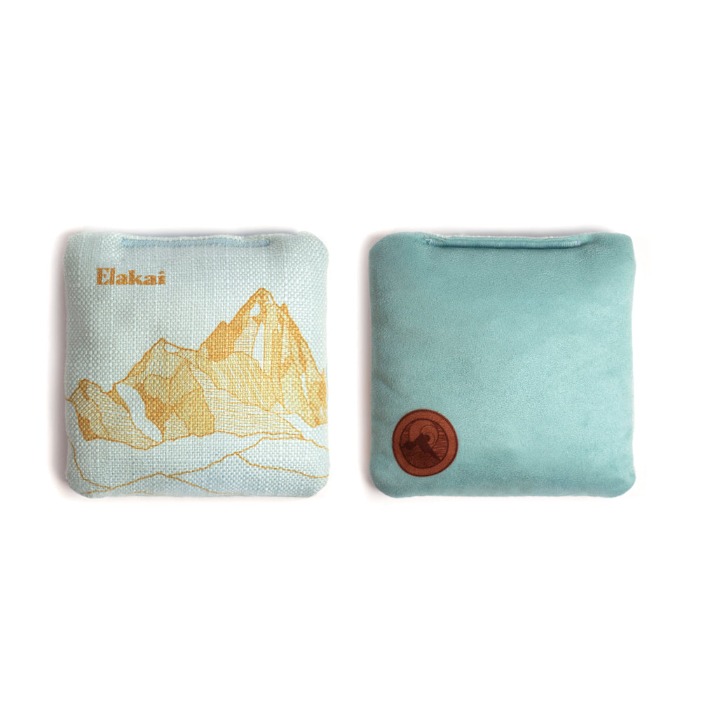 Two fabric pouches, one with a mountain design and the other plain, on a white background.