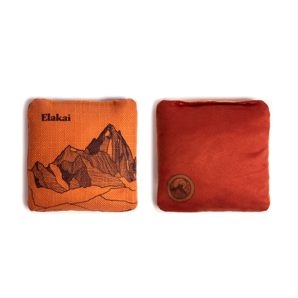Two orange fabric pouches with mountain design and Elakai branding on a white background