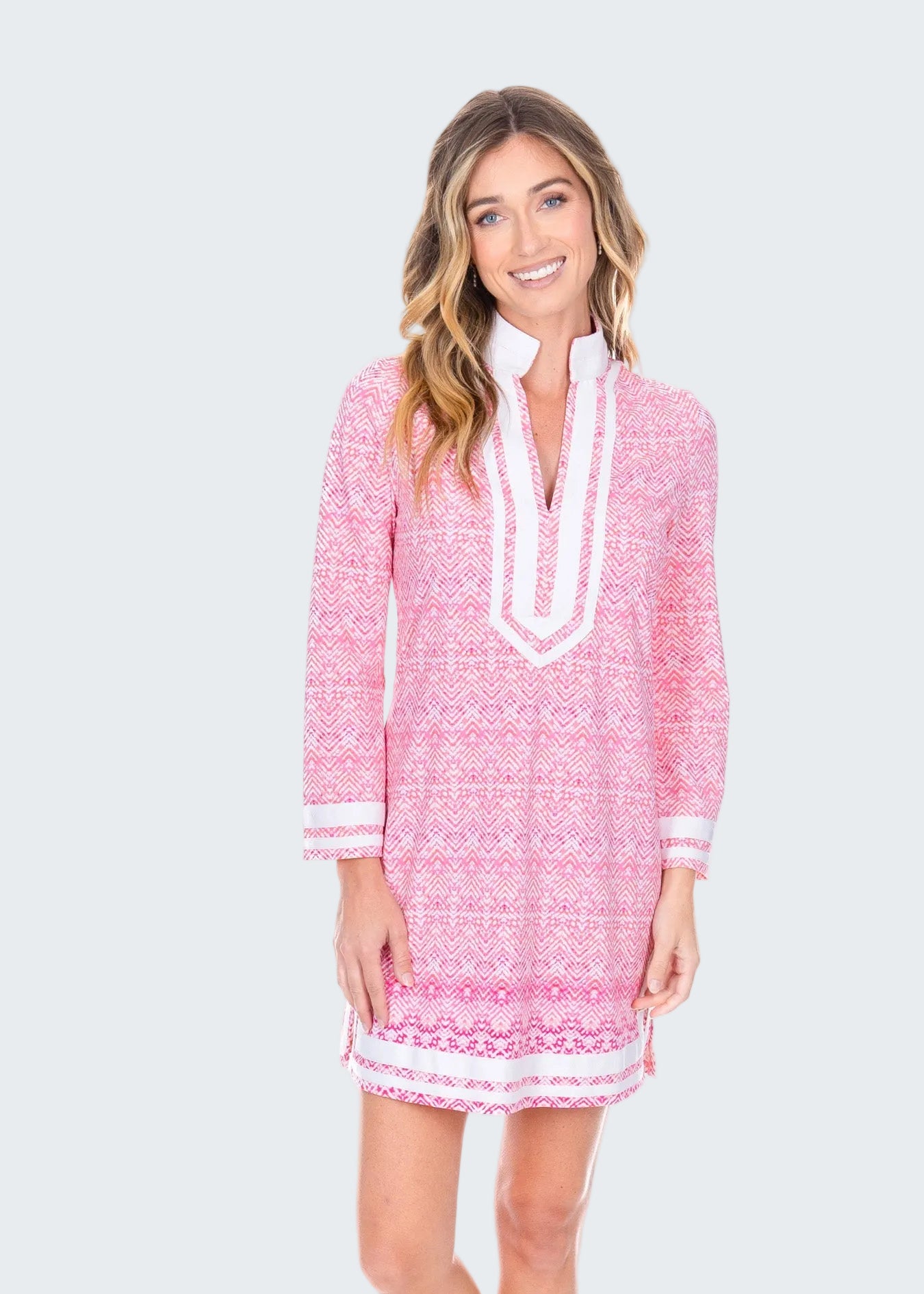 Woman wearing a pink and white patterned dress on a white background