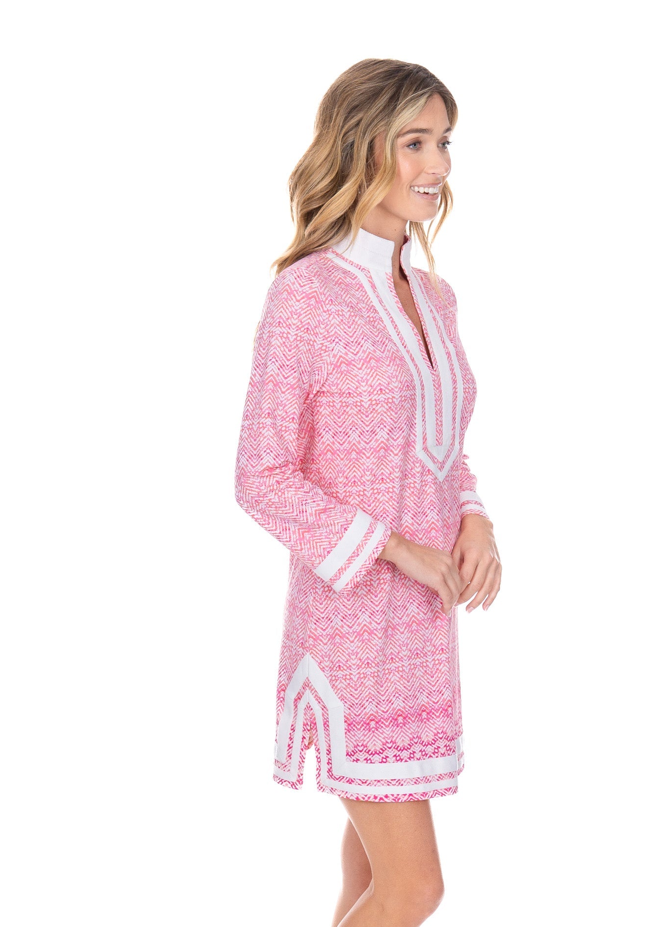 Woman wearing a pink and white patterned dress with a collar on a white background