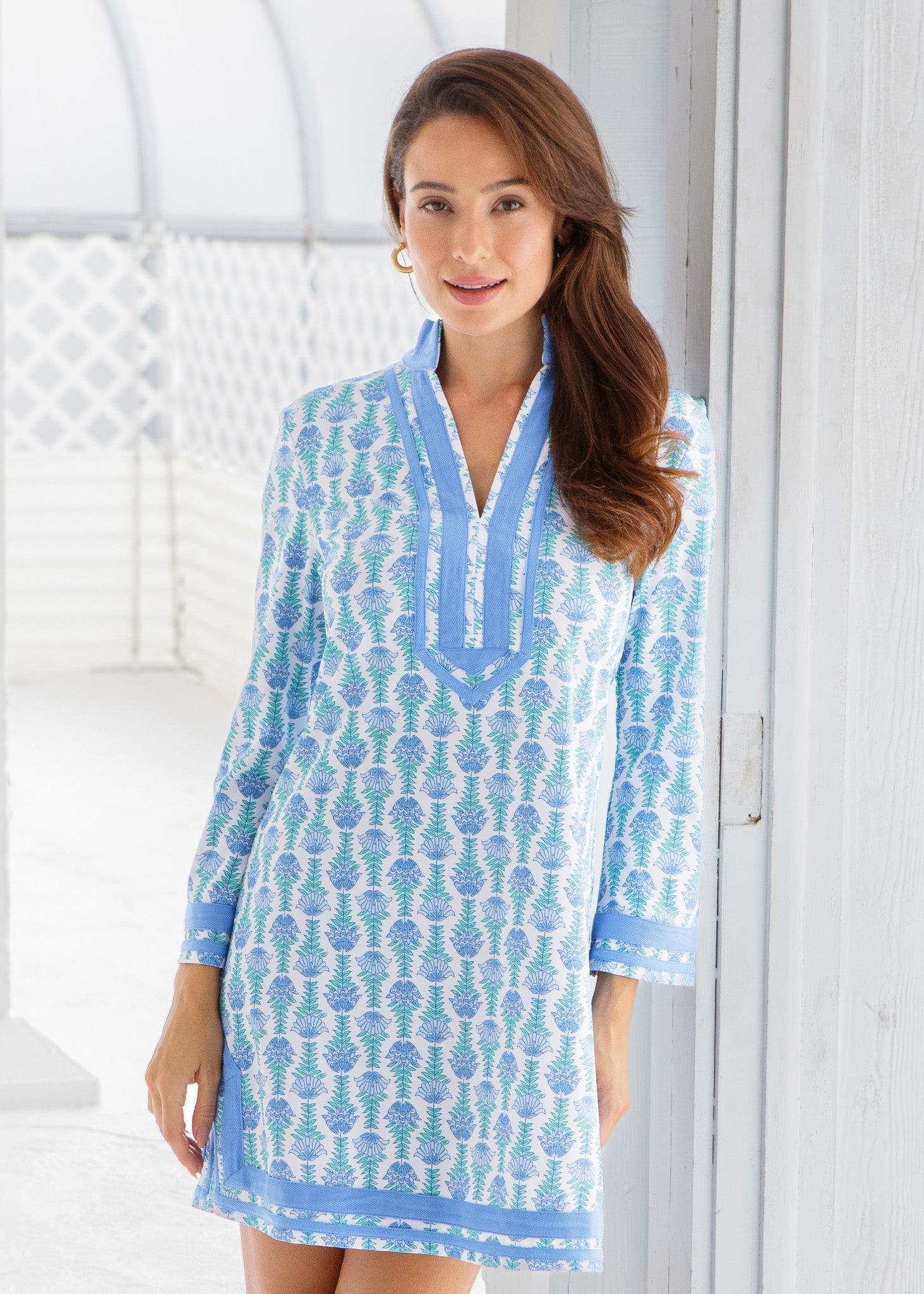 Woman wearing a blue and white patterned dress against a white background