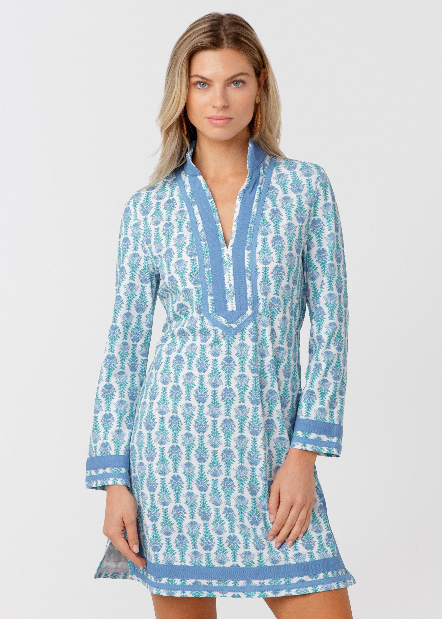 Woman wearing a blue and white patterned dress on a light gray background