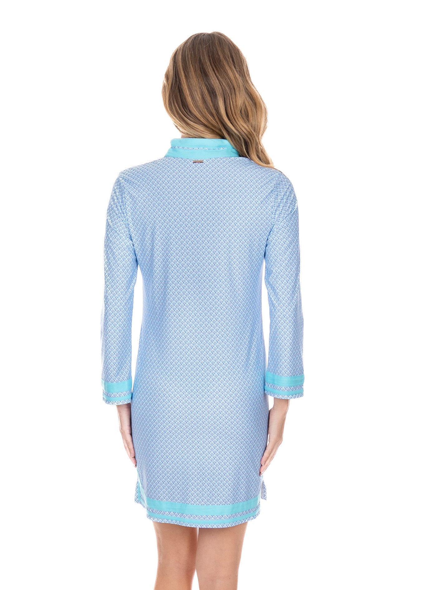 Woman wearing a light blue patterned dress with a collar on a white background