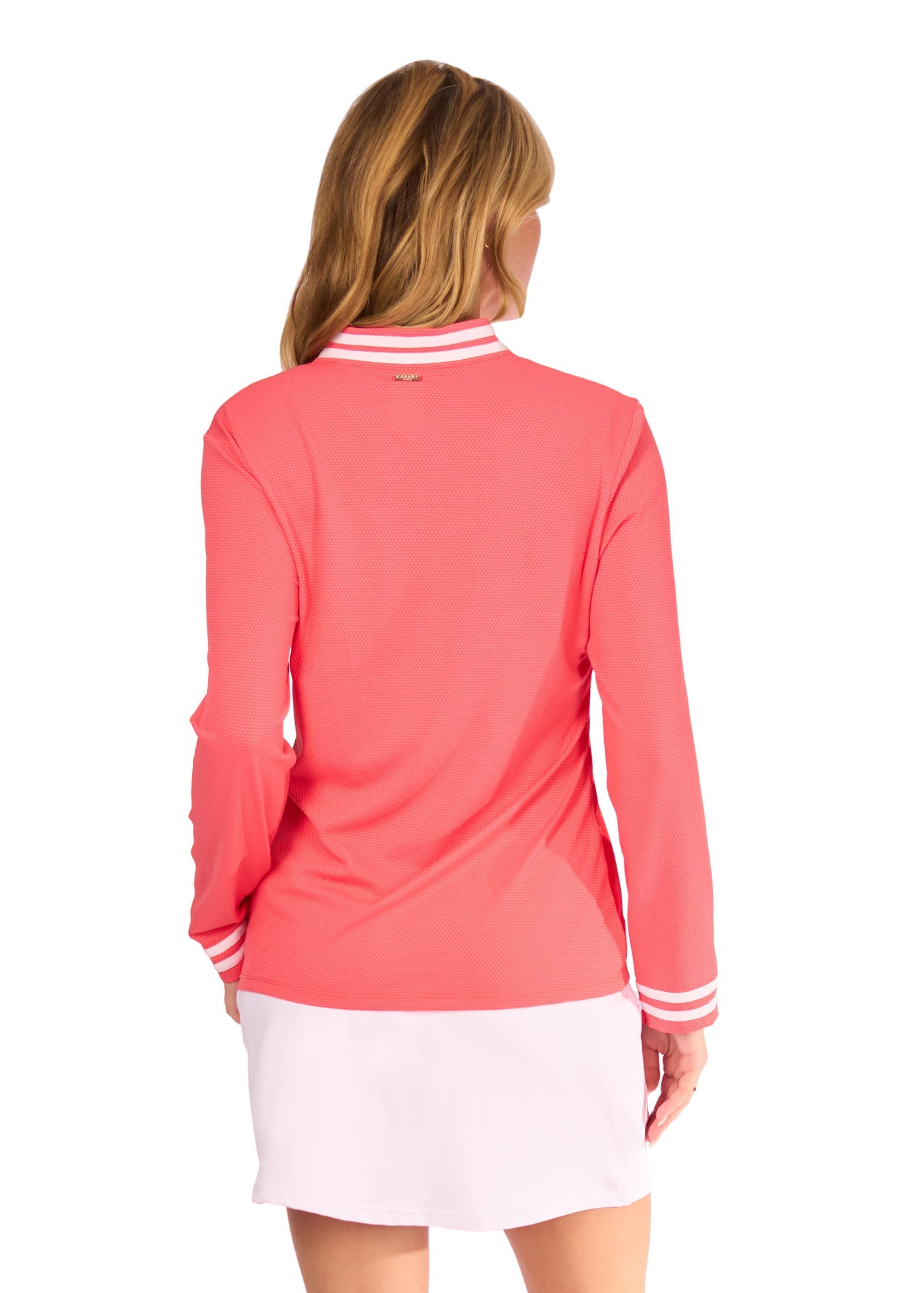 Woman wearing a coral long-sleeve top and white skirt on a white background