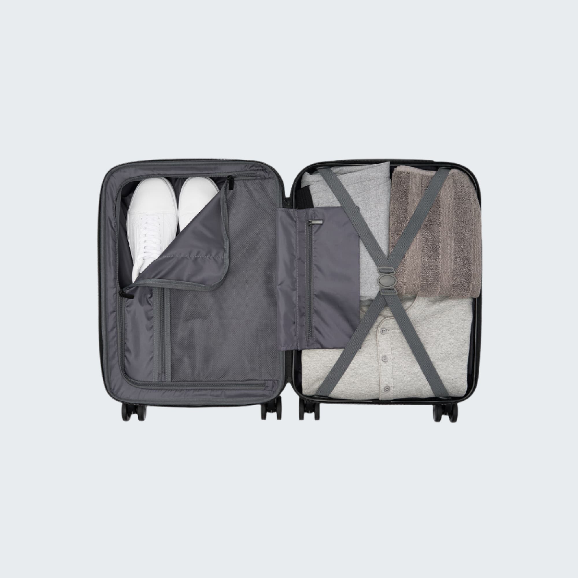 Open suitcase with clothes and shoes on a white background