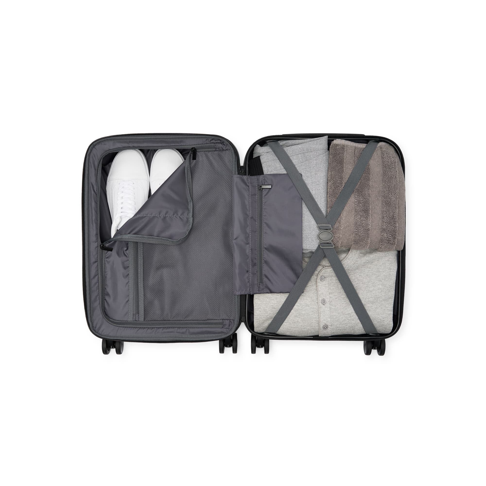 Open suitcase with clothes and shoes on a white background