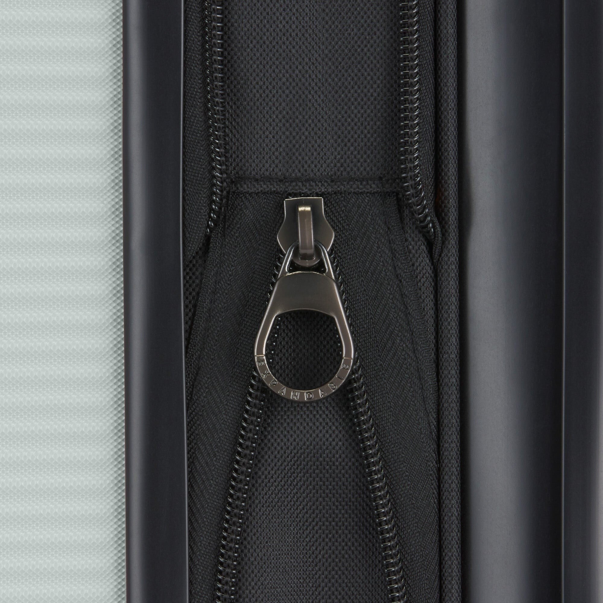 Close-up of a zipper on a suitcase with a metallic pull.