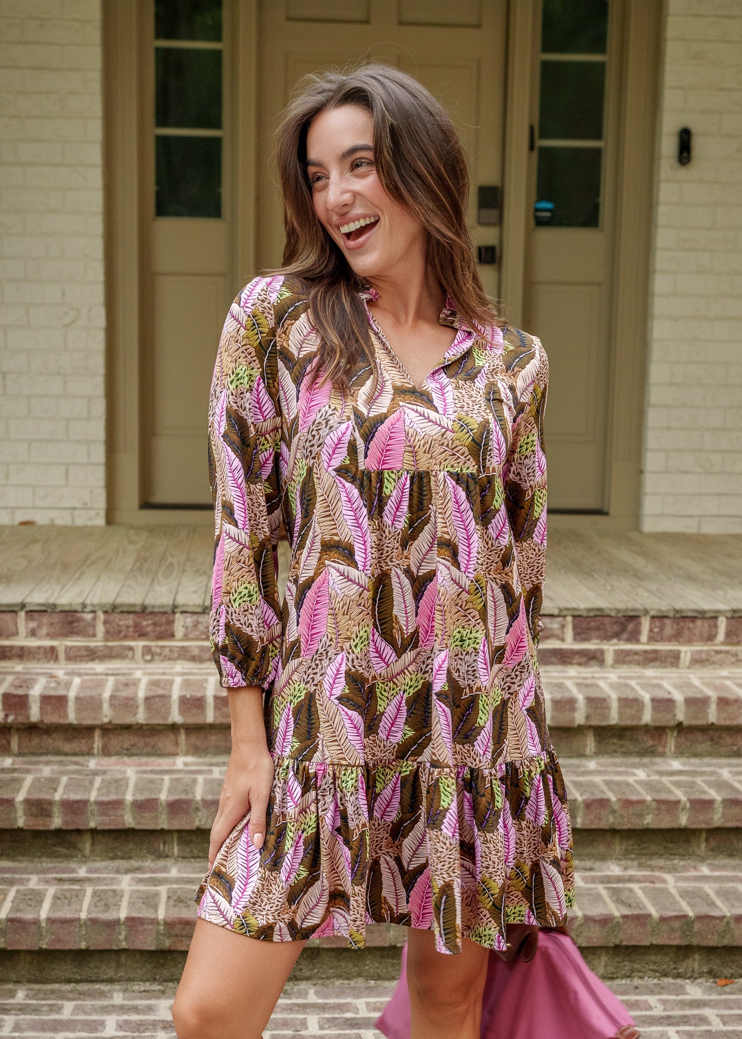 Woman in a patterned dress standing on a porch