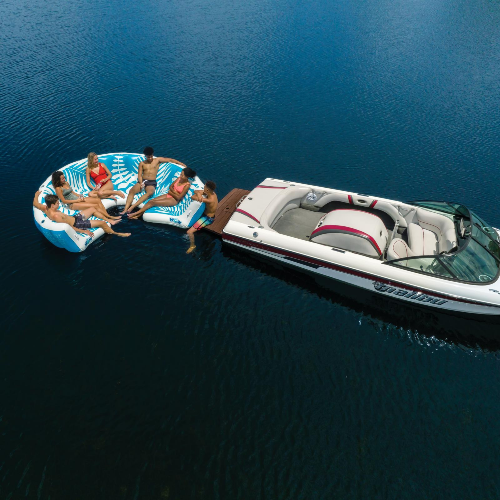 People on an inflatable pool toy being pulled by a boat on water