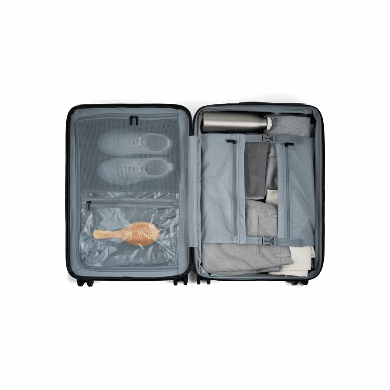 Open suitcase with organized contents on a white background