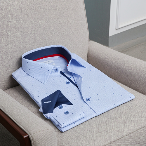 Folded white shirt with blue accents on a beige armchair
