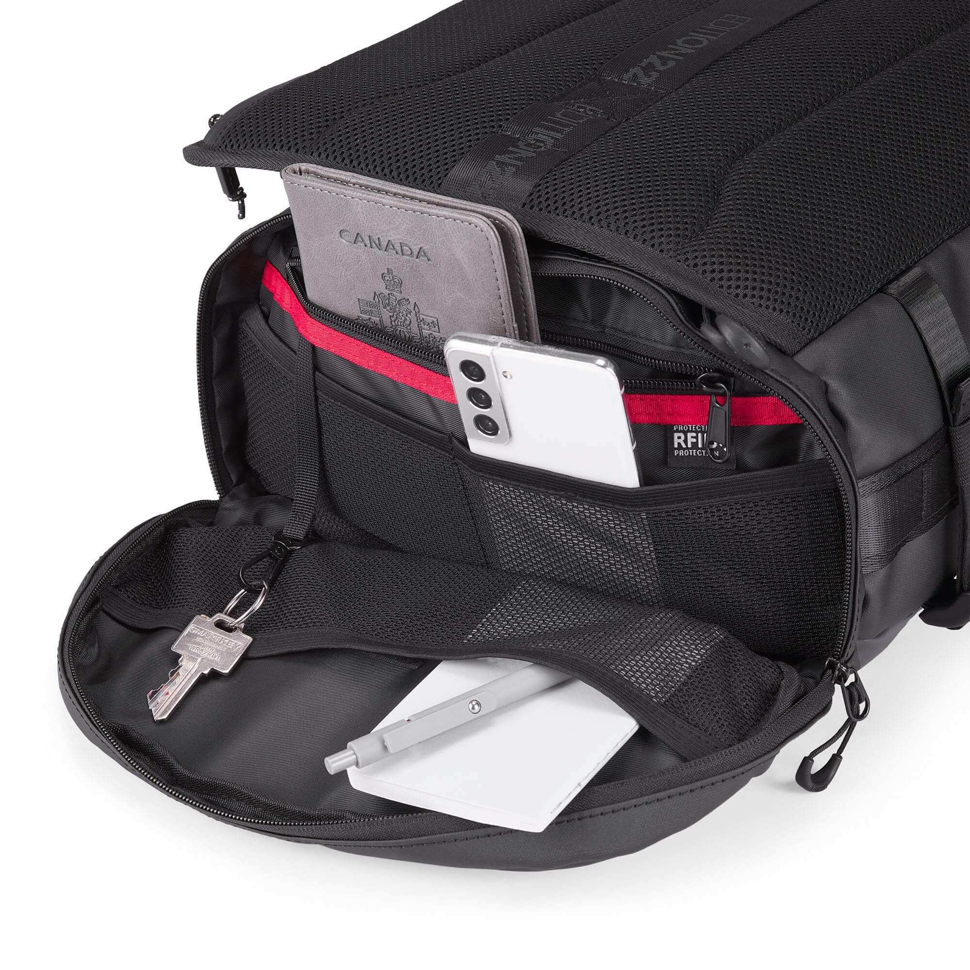 Black backpack with compartments containing a phone, wallet, and keys on a white background