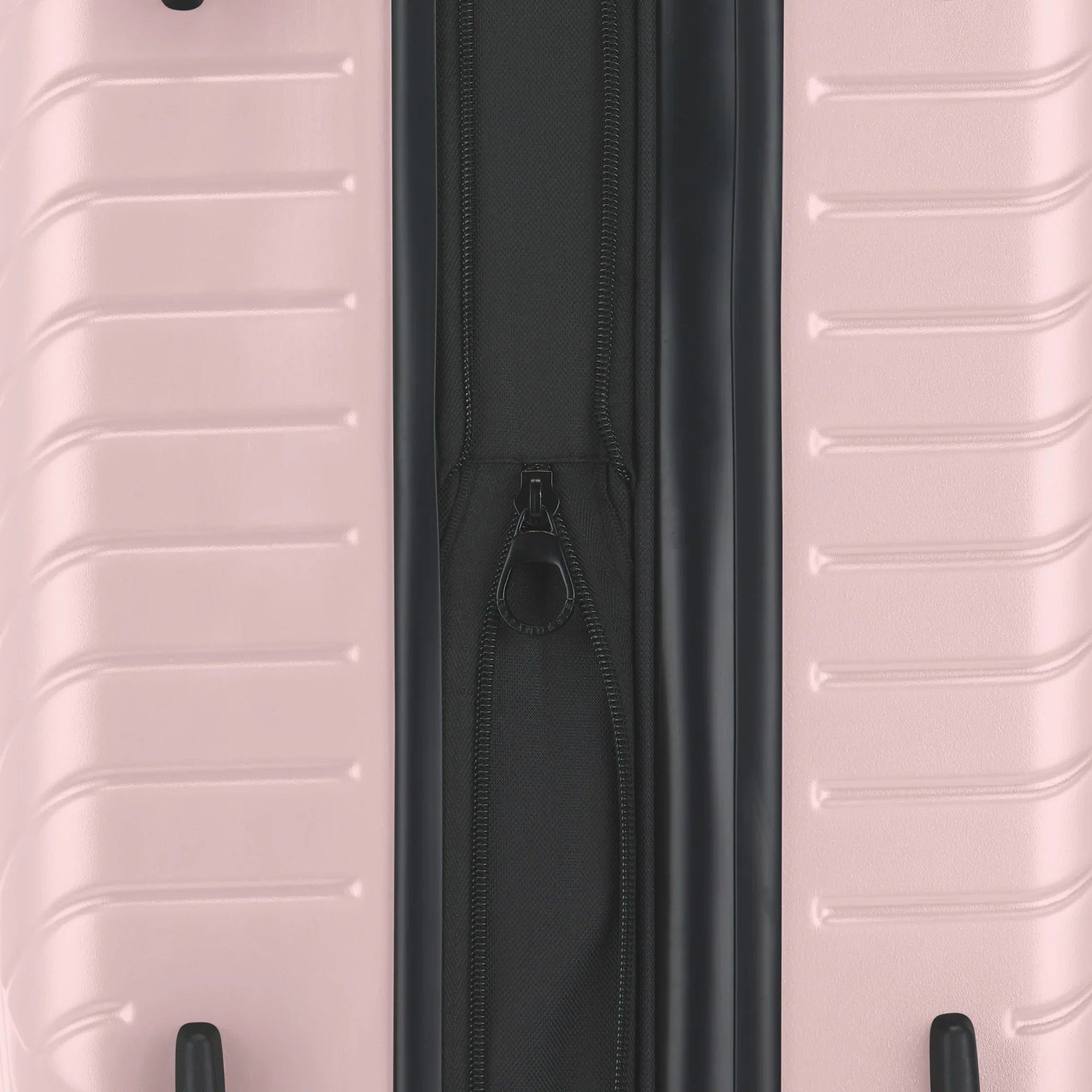 Close-up of a pink suitcase with a black zipper