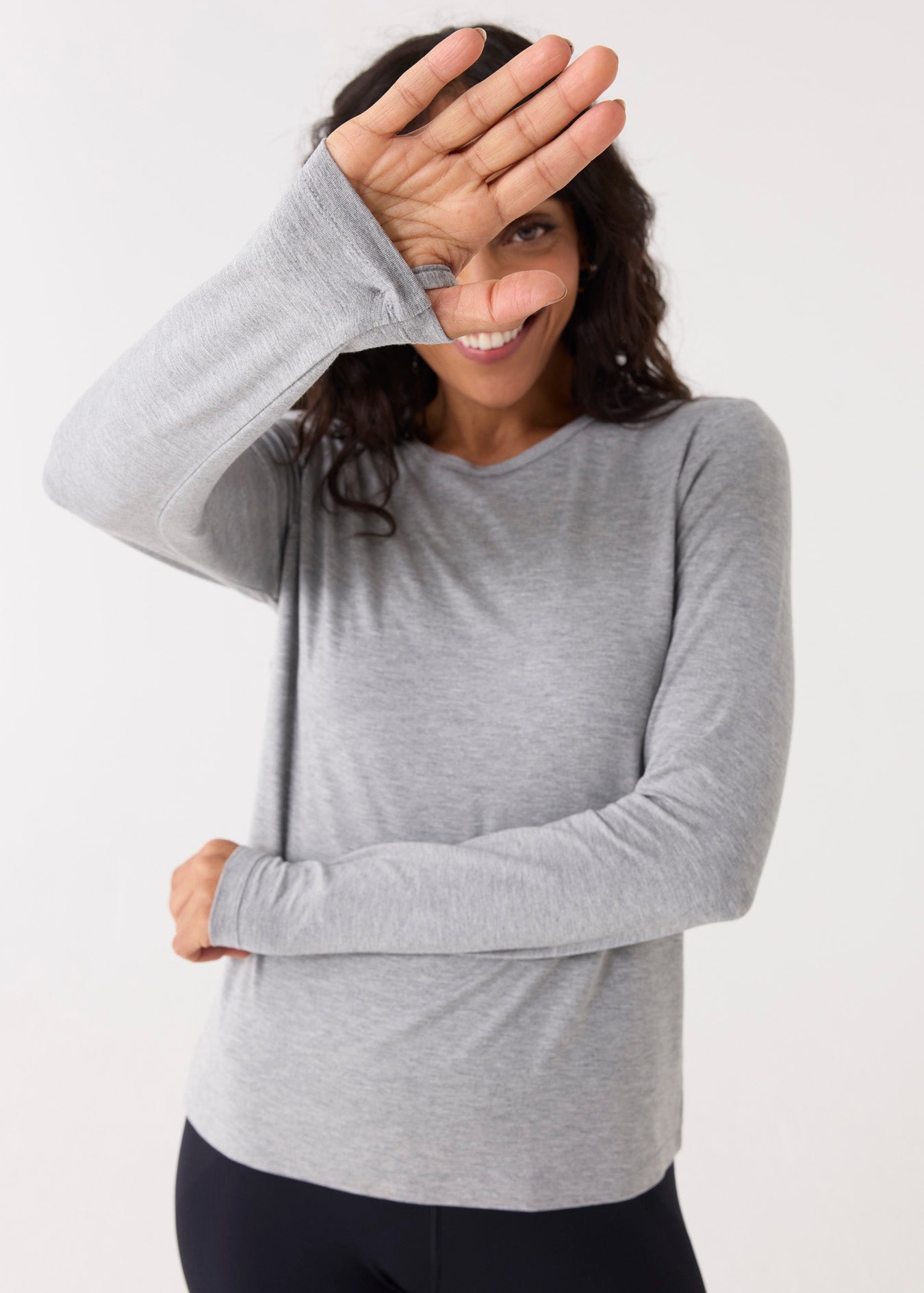 Woman wearing a gray long-sleeve top on a white background
