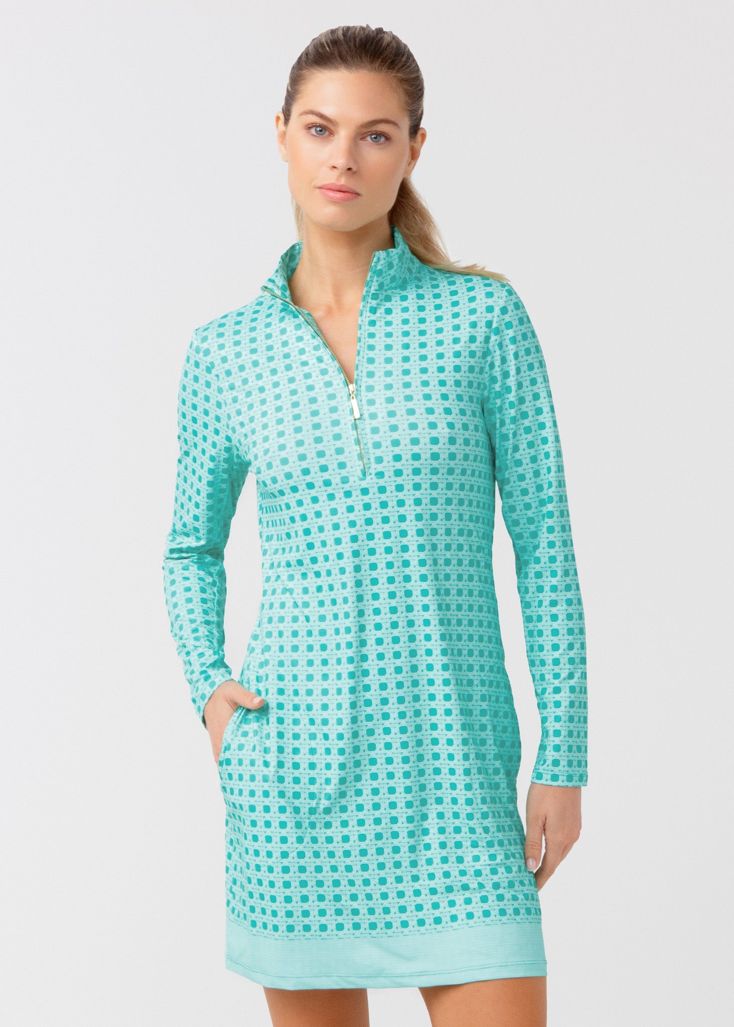 Woman wearing a teal checkered dress against a light gray background