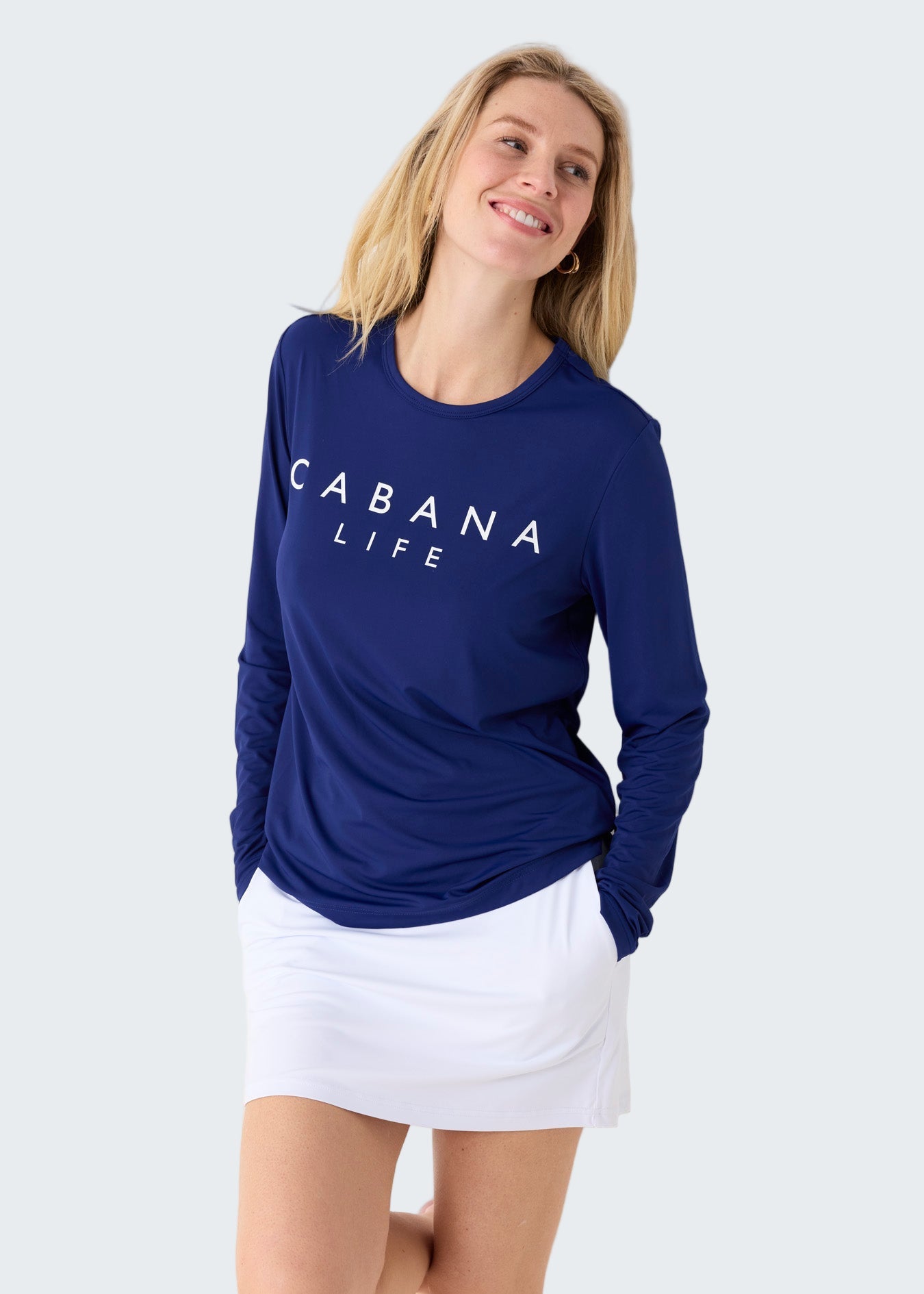 Woman wearing a blue 'Cabana Life' shirt and white skirt on a white background