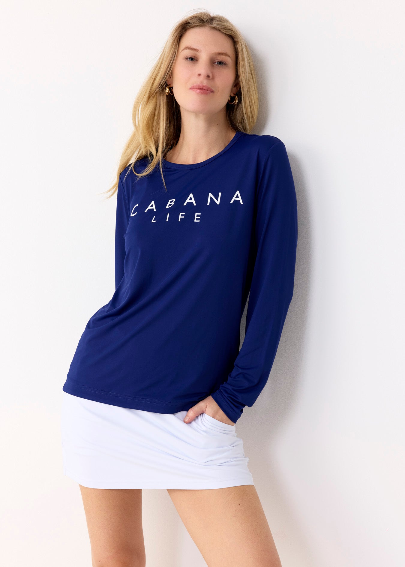 Woman wearing a navy blue 'Cabana Life' long-sleeve shirt against a white background