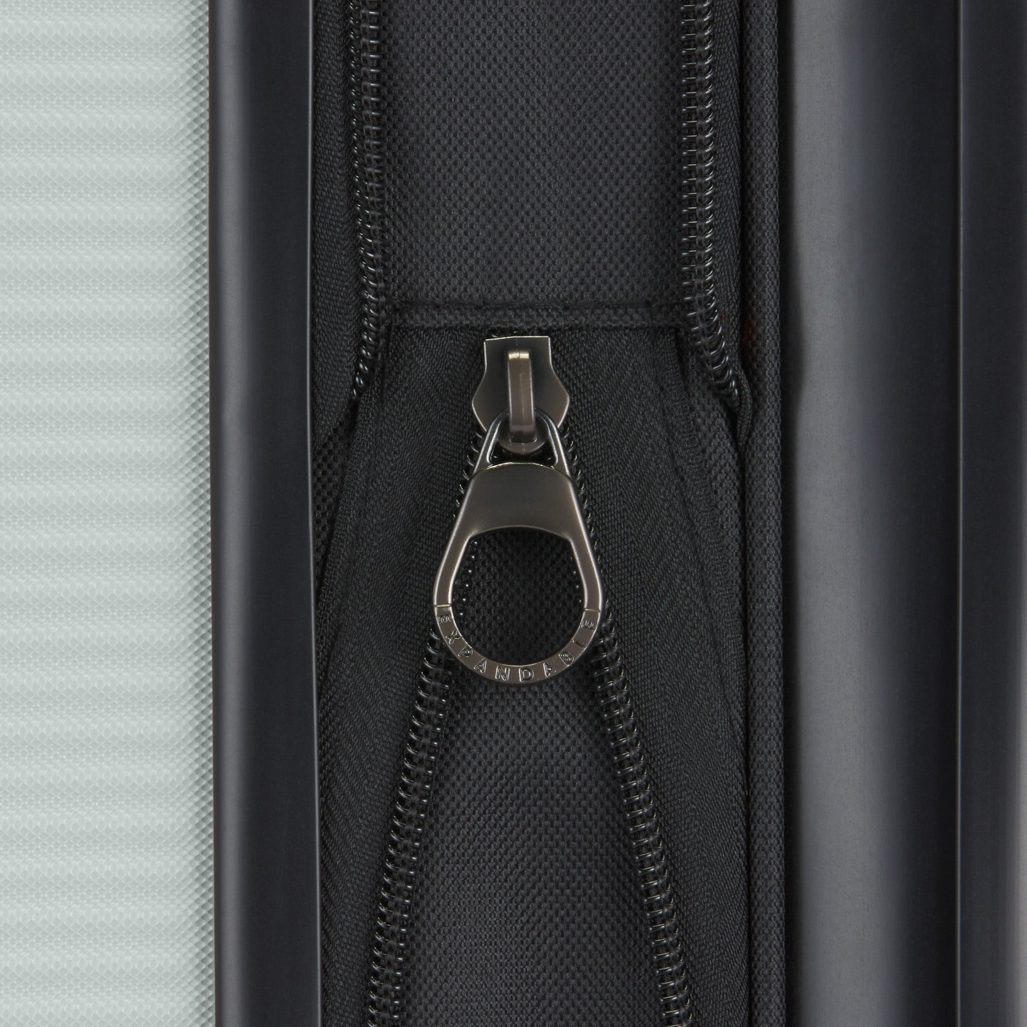 Close-up of a zipper on a suitcase with a metallic pull.